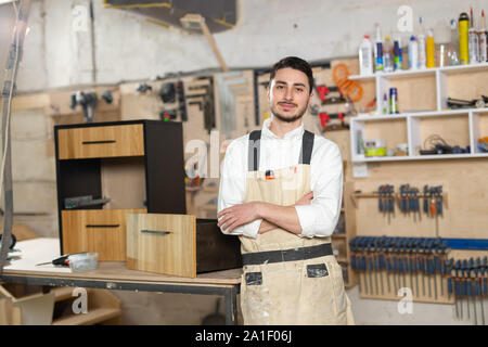 Mobili fabbrica, piccole aziende e persone concetto - Ritratto di un sorridente lavoratore di sesso maschile in fase di fabbricazione Foto Stock