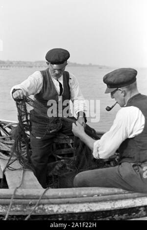 Fischer sortieren ihre Netze bevor sie sie zum Fischfang ins Meer auswerfen, Deutschland 1939. I pescatori comprese nell'assortimento le reti prima di gettarli in acqua, Germania 1939. Foto Stock