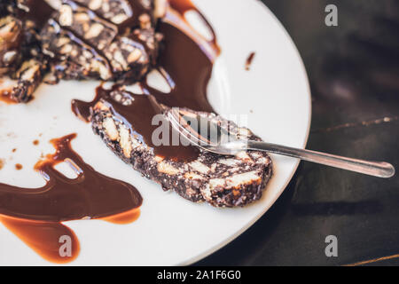 Tortino di cioccolato torta con salsa di cioccolato su una piastra bianca Foto Stock