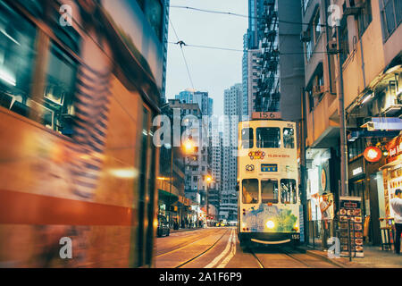 Scena serale di Kennedy Town di Hong Kong, con tram sulla strada. Foto Stock