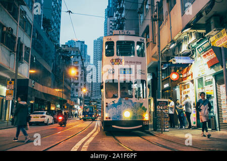 Scena serale di Kennedy Town di Hong Kong, con tram sulla strada. Foto Stock