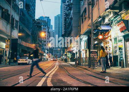 Scena serale di Kennedy Town di Hong Kong, con tram sulla strada. Foto Stock