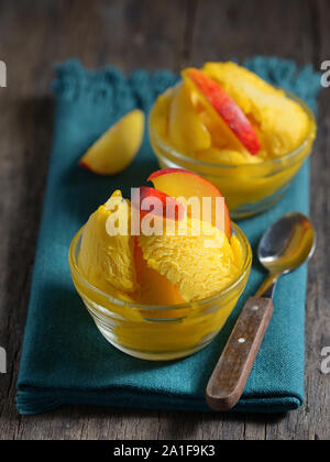 In casa mango sorbetto gelato con fette di pesche Foto Stock