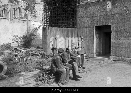 Soldaten und Polizei bewachen den Eingang zum Führerbunker im Garten der Neuen Reichskanzlei a Berlino, Deutschland 1946. Militari e polizia su sentinel all'ingresso del Fuehrerbunker nel giardino della Neue Reichskanzlei a Berlino, Germania 1946. Foto Stock