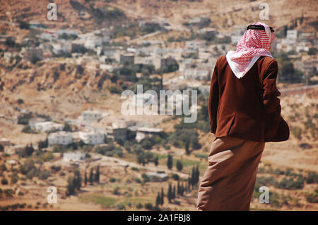 Jordanian uomo arabi che indossa gli abiti tradizionali in cima alla collina Foto Stock