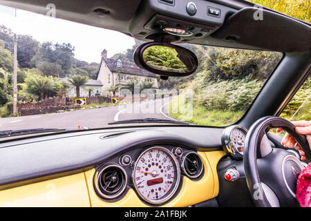 Passeggero di vista un giallo Convertible Mini Cooper salendo Porlock Hill, Somerset REGNO UNITO Foto Stock