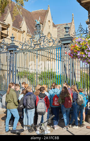Una parte della scuola di tedesco bambini al di fuori di un cancello al Trinity College dell'università di Oxford, Inghilterra. Foto Stock