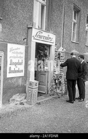 Un Touristen einem Souvenir- und Andenkenladen a Berlino, Deutschland 1962. I turisti in un negozio di souvenir a Berlino, Germania 1962. Foto Stock