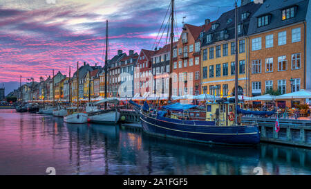 Una vista serale di colorate case a schiera lungo un canale nel quartiere di Nyhavn di Copenhagen, Danimarca. Foto Stock