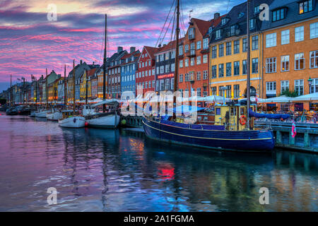 Una vista serale di colorate case a schiera lungo un canale nel quartiere di Nyhavn di Copenhagen, Danimarca. Foto Stock