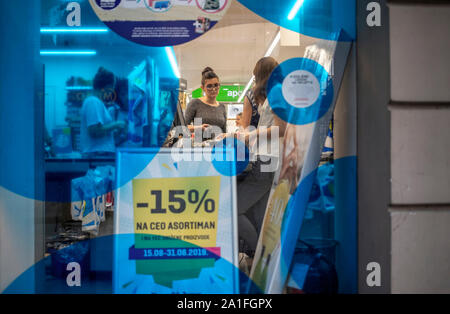 A Belgrado, in Serbia, 29 AGO 2019: vista attraverso la farmacia in vetrina della femmina di acquirenti e venditori in piedi accanto al banco a pagamento Foto Stock