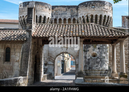 Perne-les-Fontaines, Vaucluse Francia / Agosto 21, 2019: un antico cancello che conduce alla città vecchia, famosa per le sue numerose fontane, sopra un ponte di pietra. Foto Stock