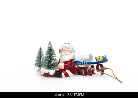 Dentista cura dentale Natale Anno Nuovo concetto card con albero di natale di Santa Claus sled spazzolino e dentifricio. Foto Stock