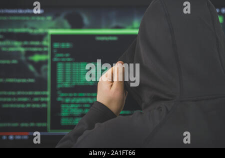 Hacker in felpa con cappuccio nero. Hacking e sicurezza internet concetto. Foto Stock
