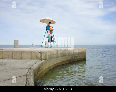 Bagnino guardando su una torre in spiaggia in Europa Foto Stock