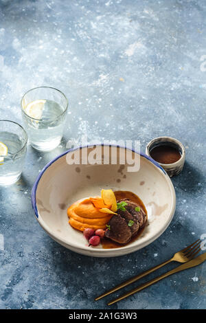 Slow brasati di carne di agnello con patate dolci purea, ristorante Dish, copia dello spazio. Foto Stock