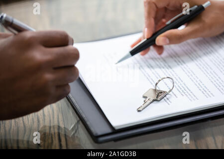 Firma del proprietario immobiliare di contratto con tasti Foto Stock