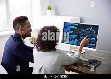 Stock Broker di mercato Analisi di grafici sul computer in ufficio Foto Stock