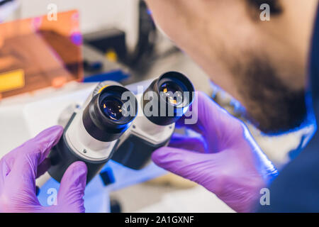 Il lavoro dello scienziato in un confocale microscopio a scansione in un laboratorio per i campioni biologici inchiesta. Foto Stock