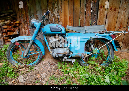 Un vecchio abbandonato cavalletto di motoveicoli nei pressi di una recinzione Foto Stock