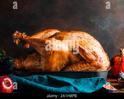 Arrosto di tacchino intero su un tavolo con Apple, la zucca e le figure per la famiglia per la Festa del Ringraziamento. Foto Stock