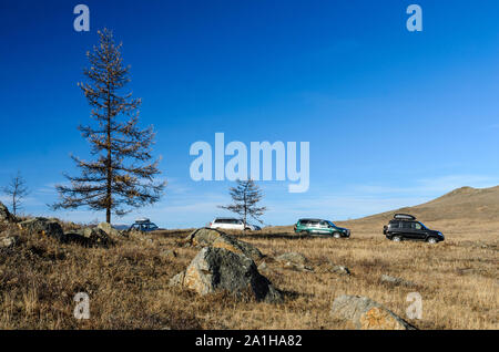 Regione di Irkutsk, Russia, Sakhurta - 19 ottobre 2013: Soggiorno di quattro auto nella steppa di Tazhenranskaya sulla costa occidentale del lago Baikal, Siberia Foto Stock