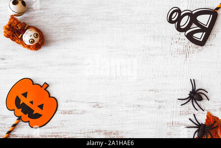 Lay piatto happy Halloween festival del concetto di sfondo. Mix accessorio di varietà di oggetti di decorazione su grunge stile rustico in legno bianco. Vista da sopra con copia s Foto Stock