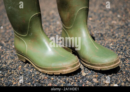 Verde sporco stivali di gomma closeup in giardino Foto Stock