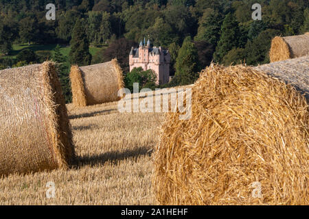 Una vista verso il Castello di Craigievar in Aberdeenshire con le balle di paglia in primo piano Foto Stock