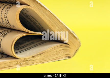 Cuore della carta è fatta dal libro di pagine su color pastello sullo sfondo. Il concetto di amore. Foto Stock