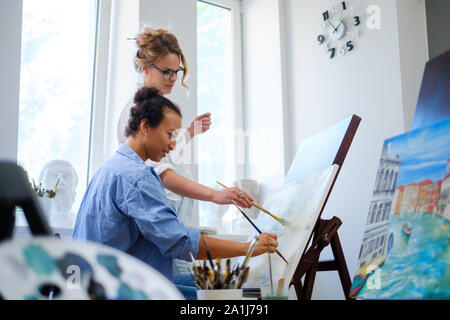 Pittore creativo e il suo pupillo di lavorare in un studio Foto Stock