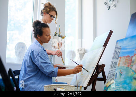 Pittore creativo e il suo pupillo di lavorare in un studio Foto Stock