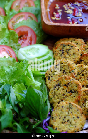 Close up vietnamita cibo vegan, verde fagiolo torte con insalata di pomodoro e salsa, saporito piatto per il pasto vegetariano, uno spuntino o una prima colazione Foto Stock