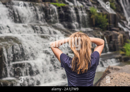 Giovane donna escursionista, turistico sullo sfondo di incredibile cascata Pongour è famosa e più belli di cadere in Vietnam. Non lontano dalla città di Dalat est Foto Stock