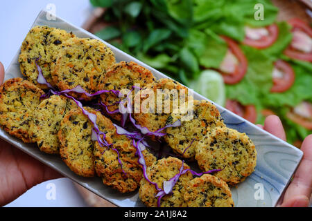 Vietnamita cibo vegan, close up verde fagiolo torte su insalata di pomodoro, sfondo sfocato, saporito piatto, Nutrizione Alimenti per pasto vegetariano, snack o dove siamo Foto Stock