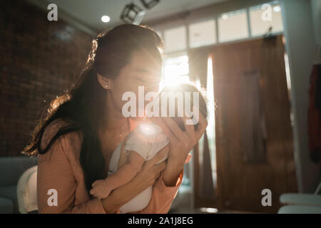 Madre baciando la sua piccola figlia Foto Stock