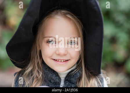 Bella ragazza strega. bambina in costume che festeggiare Halloween all aperto e hanno un divertimento. Trucco per bambini o il trattamento. Foto Stock