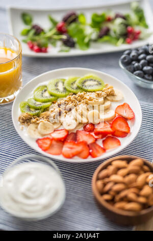 Una sana colazione la colazione è servita con la piastra di yogurt muesli kiwi fragole e banane Foto Stock
