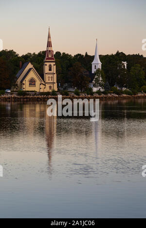 Tre chiese lungo il litorale di Mahone Bay, riflessa nell'acqua all alba di una bella giornata. Foto Stock