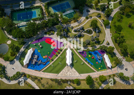 Antenna top down foto del bellissimo parco architettonico con il colorato parco giochi per bambini Campo da tennis e putting green. Foto Stock