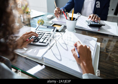 Due colleghi di lavoro Calcolo delle imposte in Office Foto Stock