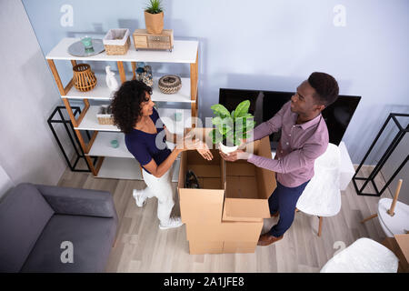 Giovane Disimballaggio scatole in soggiorno nella loro nuova casa Foto Stock