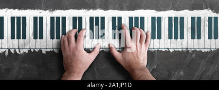 Vista dall'alto delle mani della persona suonare il pianoforte disegnato sulla lavagna o lavagna Foto Stock