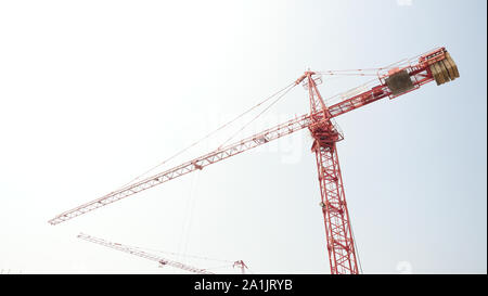 Torre Rossa gru nella costruzione della struttura area con cielo blu in background, macchinari e grandi attrezzature di lavoro Foto Stock