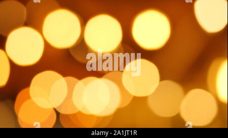 Molti luce dorata cerchi su sfondo marrone per la celebrazione delle feste, Bokeh da illuminazione per interni Foto Stock