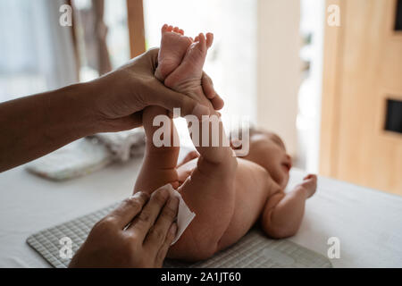 Padre asiatici sfregamento baby glutei Foto Stock