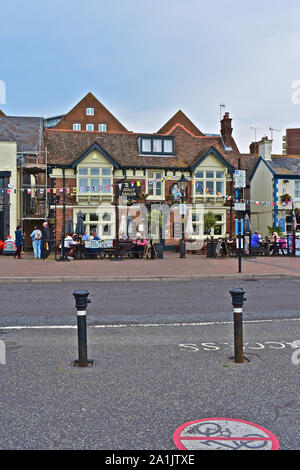 La gente seduta al di fuori del pub lungo il porto di Poole, compreso il Jolly Sailor e il Lord Nelson. Foto Stock