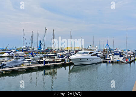 Un assortimento di piacere progetto & barche da pesca ormeggiate nella sicurezza del porto di Poole Quay Boat Haven entro il porto. Motor yacht ormeggiati davanti. Foto Stock