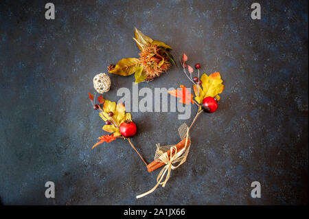 Sfondo con foglie di autunno con forma di cuore posato su uno sfondo blu scuro, utile anche immagine per un stile di Natale Foto Stock
