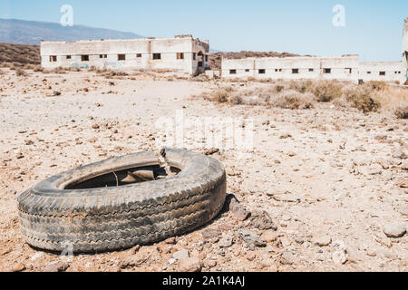 Vecchia auto pneumatico oggetto di pratiche di dumping nel paesaggio del deserto Foto Stock